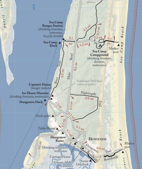 Trail and facility map of the northern end of Cumberland Island, showing key locations including the Dungeness Ruins, Sea Camp Campground, Sea Camp Ranger Station, and Dungeness Dock. The map highlights trails, distances in miles, drinking fountains, restrooms, showers, and points of interest like the Ice House Museum and Carriage House.