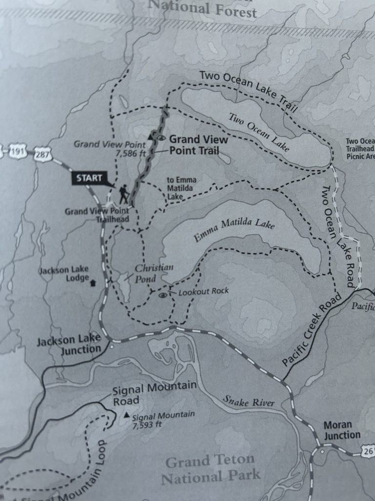 A black-and-white trail map of Grand Teton National Park shows the Grand View Point Trail, Two Ocean Lake Trail, and surrounding landmarks. The map marks features such as Emma Matilda Lake, Christian Pond, Lookout Rock, Signal Mountain, and nearby roads, with dashed lines indicating hiking paths and solid lines for roads.