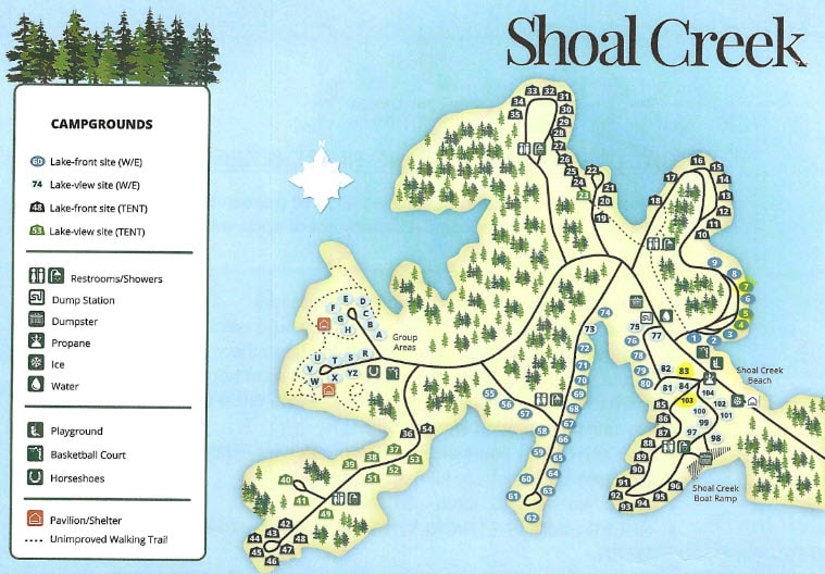 Illustrated campground map of Shoal Creek Campground showing lakefront and lake-view campsites, restrooms, group areas, and recreational amenities. Icons indicate locations for water, dump stations, playgrounds, trails, pavilions, and the Shoal Creek Beach and Boat Ramp. The campground layout follows the shoreline with several loops extending into Lake Lanier.